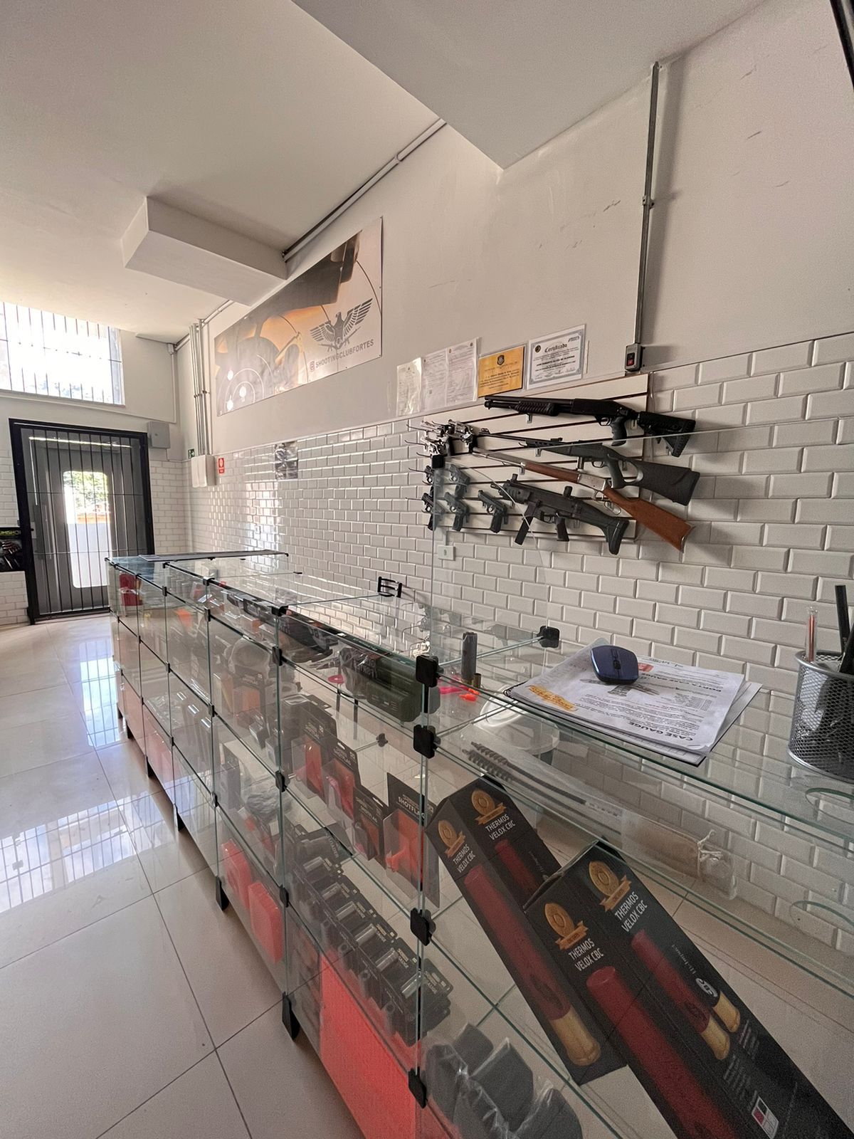 Loja de armas do Shooting Club com vitrines e armas em exposição